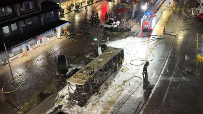 Emergency responders work near a burned bus in Kerzers, Switzerland, after a deadly fire killed six and injured several passengers